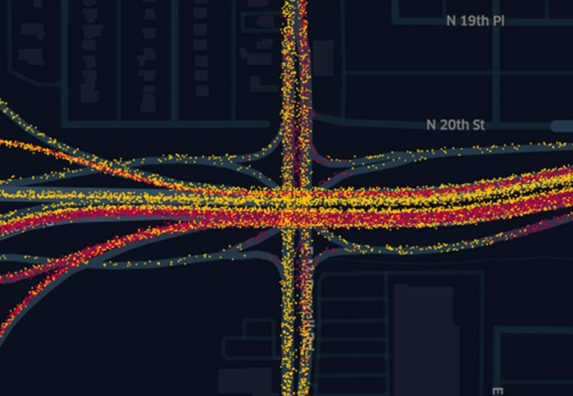Screenshot from video representing connected vehicle speed and position at a major intersection. Many colored dots make up the image with the colors representing different speeds.