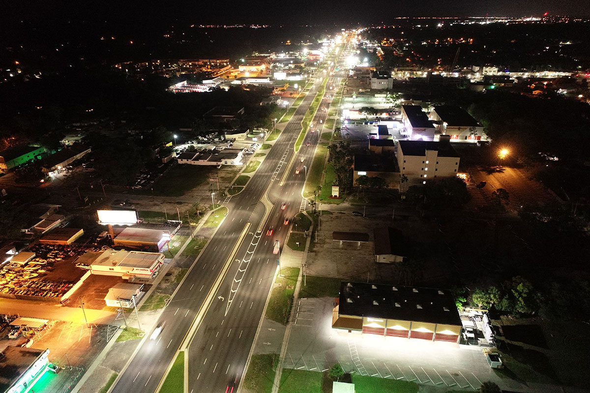 Nighttime aerial image of a 6-lane roadway through an urban corridor.