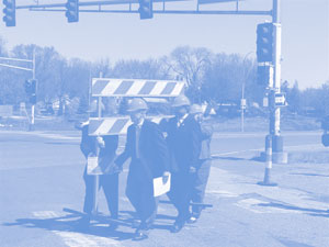 FHWA Minnesota Division Administrator Tom Sorel, Minnesota DOT Metro District Engineer Khani Sahebjam, Minnesota Lieutenant Governor/DOT Commissioner Carol Molnau and an unidentified man move a barrier into place at a May ceremony to close part of Highway 36 for rapid reconstruction.