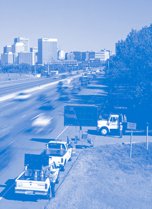 busy interstate with work trucks on the side of the road