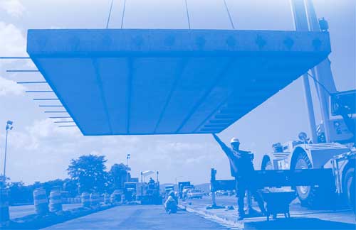 Photograph of slab being lowered onto a highway. Precast concrete pavement systems speed work and cut congestion on repair jobs in high-traffic areas.