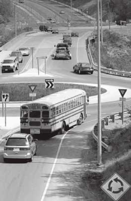 Roundabout in the United States showing traffic including a school bus.