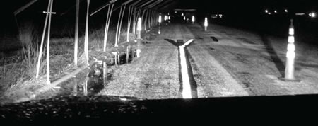 Photograph of a simulated work zone showing the visibility of pavement marking samples along road at night.