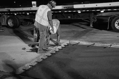 Showcase participants watched the nighttime placement of precast concrete pavement slabs in California