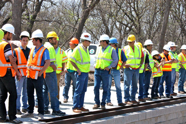 Transportation professionals observed as crews placed abutment layers at a GRS-IBS demonstration showcase in Oklahoma.