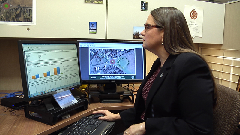 Photo of woman viewing Data Driven Safety Anaylsis programs on two computer monitors.