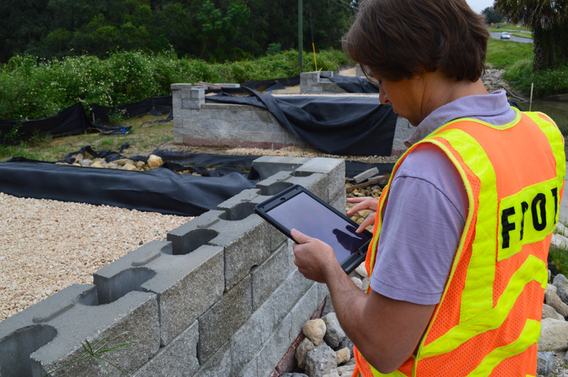 Photo of a worker using a mobile device at a construction site.