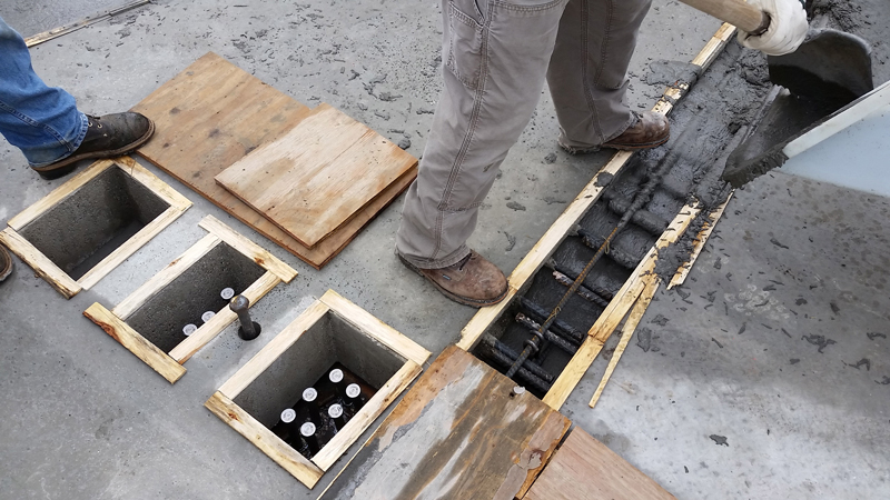 Photo of a worker using ultra-high performance concrete to form a connection between prefabricated deck panels on the Western Avenue Bridge project.