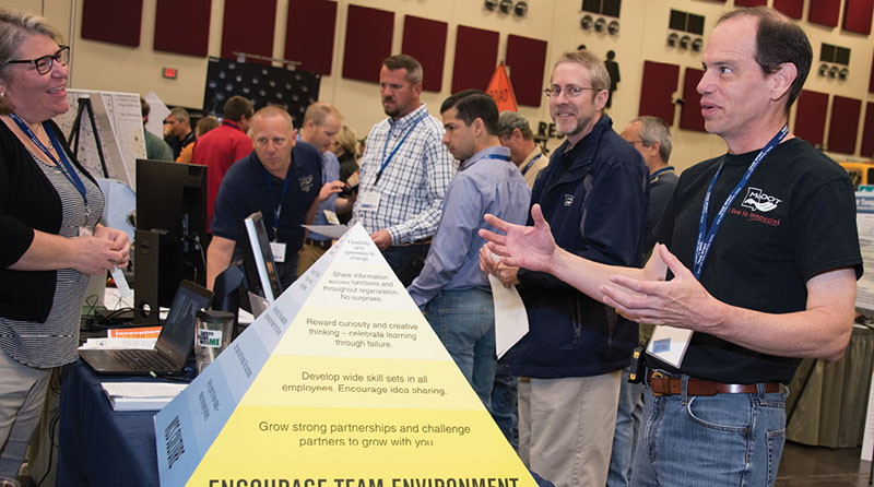 Photo of MoDOT employees talking at display table.