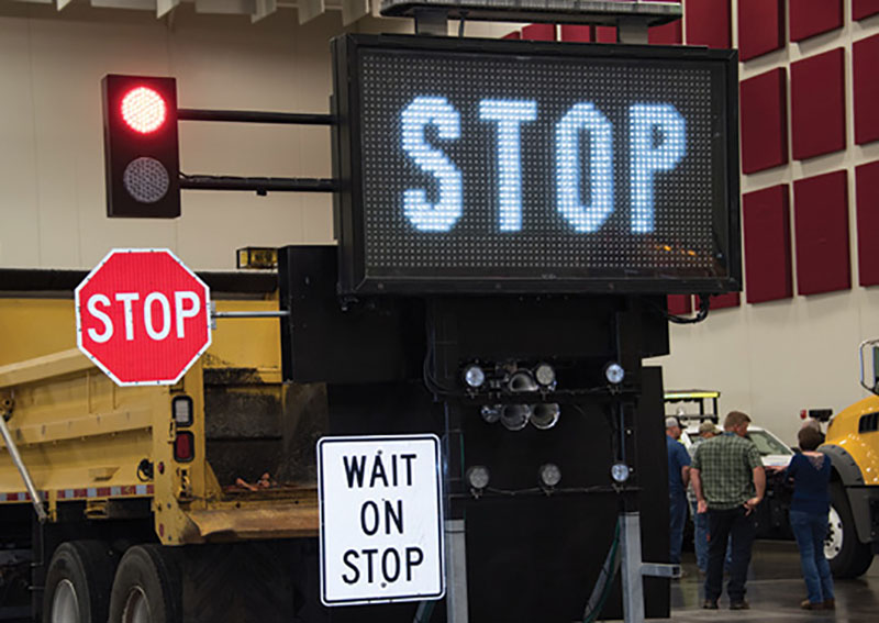 Photo of work truck with a stop-slow paddle and digital message sign mounted on the back.