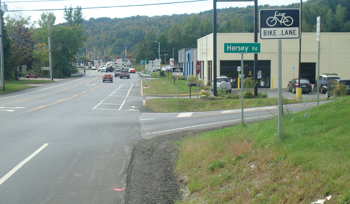 Photo of road diet with three vehicle lanes and two bicycle lanes.