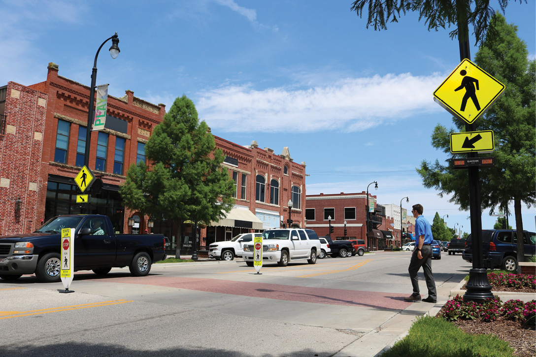 Pedestrian crossing a street at a crossing with RRFB.