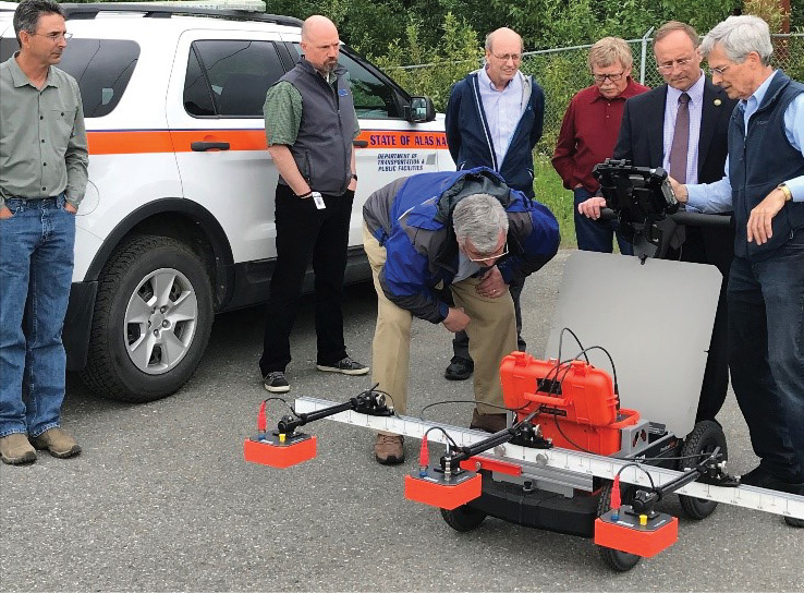 Alaska STIC members gathered around ground-penetrating radar equipment.