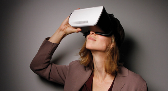 Photo of a woman in business attire using virtual reality goggles.