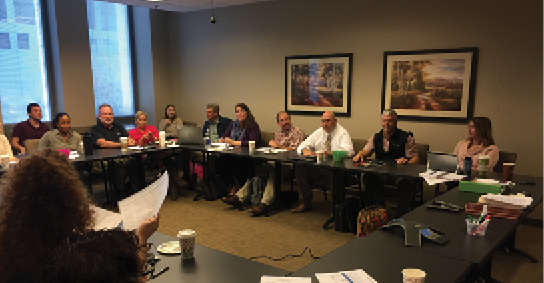 People seated around a table in a conference room.