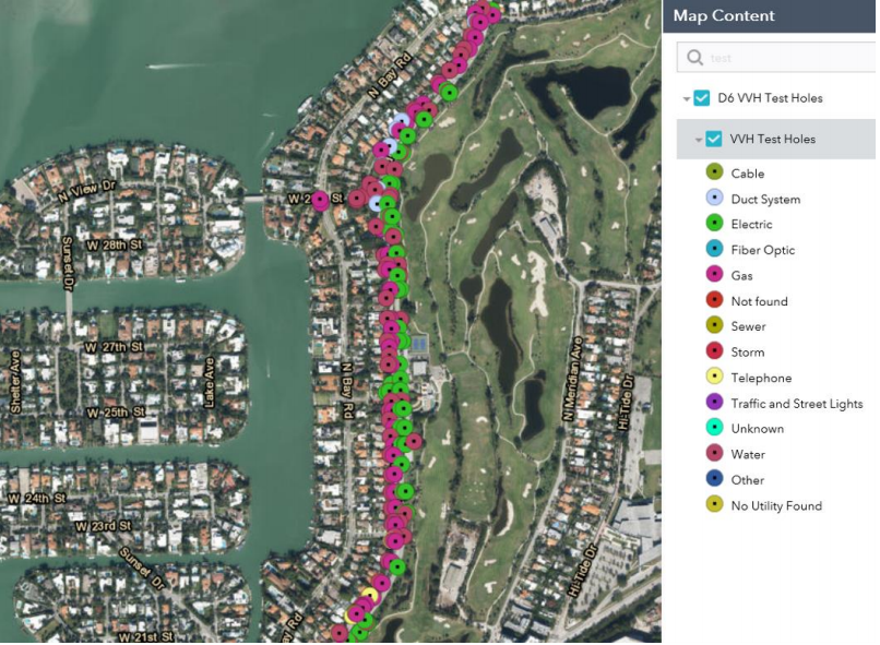 Aerial photograph of a coastal community marked with dots representing previous test hole locations.

