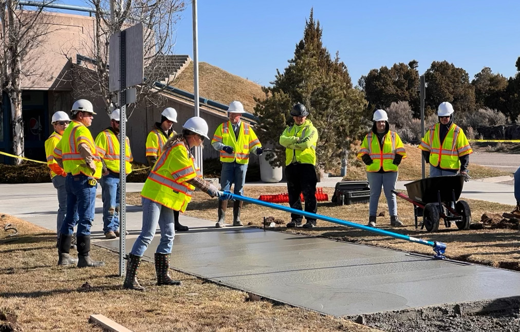 Photograph of ICONIC training program students replacing a concrete sidewalk at an interstate rest area.
