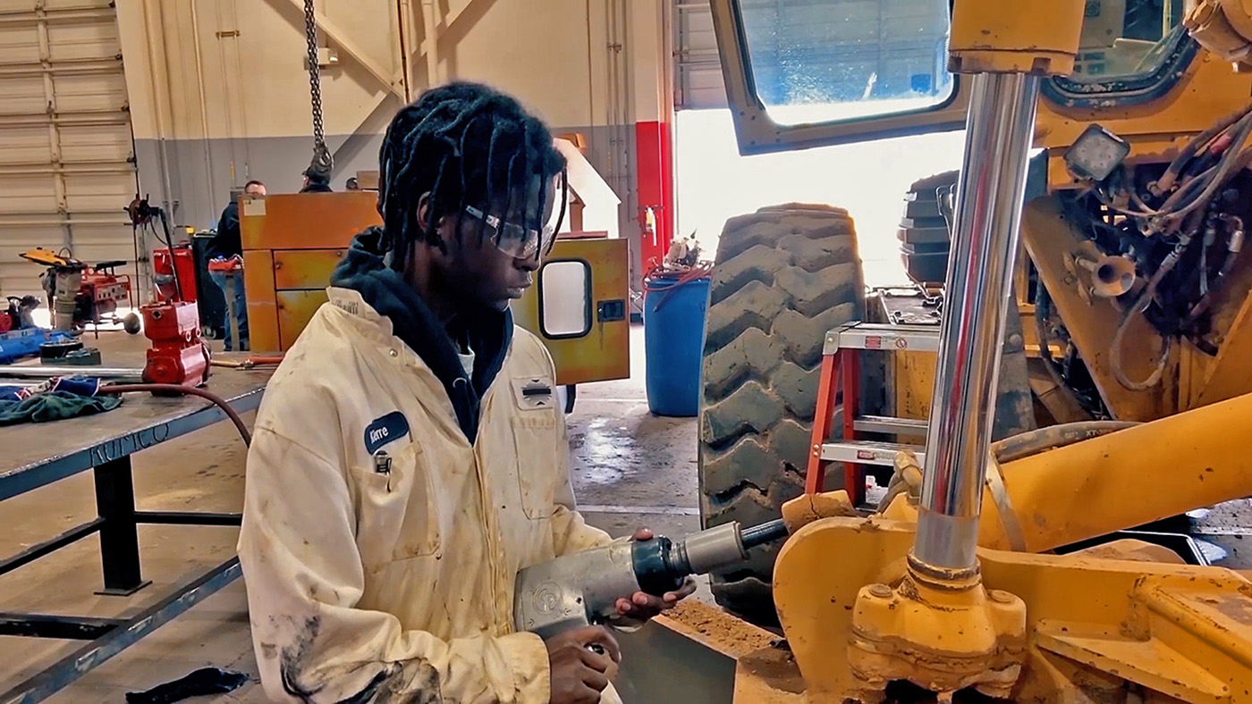 Young man working on a road utility vehicle.