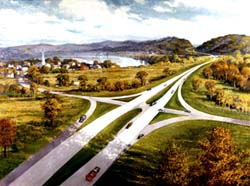 In a fall setting, an aerial view of a highway interchange with a small town in the background.