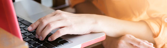 Computer with hand on keyboard