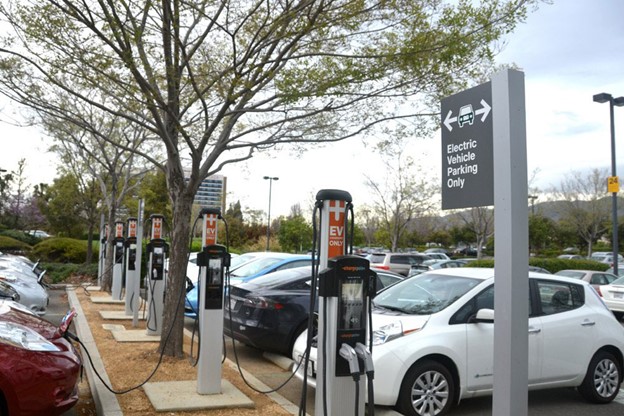 electric vehicle parking with several cars and dual port fast charging stations