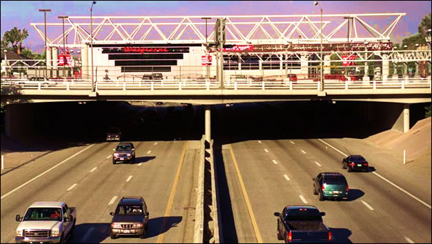 The store with its tubular architecture and its parking lot shown with six lanes of highway traffic passing underneath.