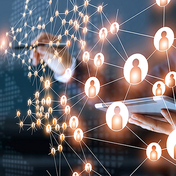 A person with a stylus pointing at a digital wall of network and people icons