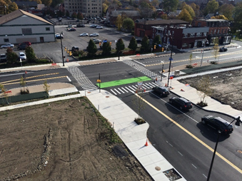 A aerial photograph of a reconstructed intersection in the Inner Loop East, including large sidewalks, pedestrian crosswalks, and room for bicyclists.