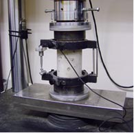 An image of a 6-inch diameter by 12-inch-high concrete cylinder undergoing a compression test
