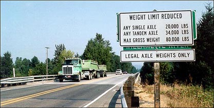 The photograph on the right shows a two lane bridge. There is a tractor trailer in the left lane. No traffic appears in the right lane. A sign appears to the right of the right lane. The sign reads "Weight Limit Reduced - Any Single Axle - 20,000 LBS - Any Tandem Axle - 34,000 LBS - Max Gross Weight - 80,000 LBS - Legal Axle Weights Only"
