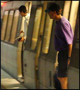 Picture 4. Graphic. The picture shows the side of a metro-transit car with two passengers exiting through the open doors onto a platform.