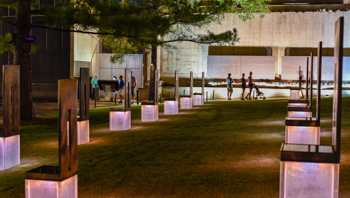Photo: Field of Empty Chairs anf Survivor Wall at Night