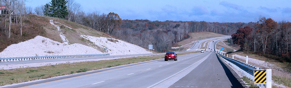 A red car travels along Interstate 69 through Indiana’s rural landscape