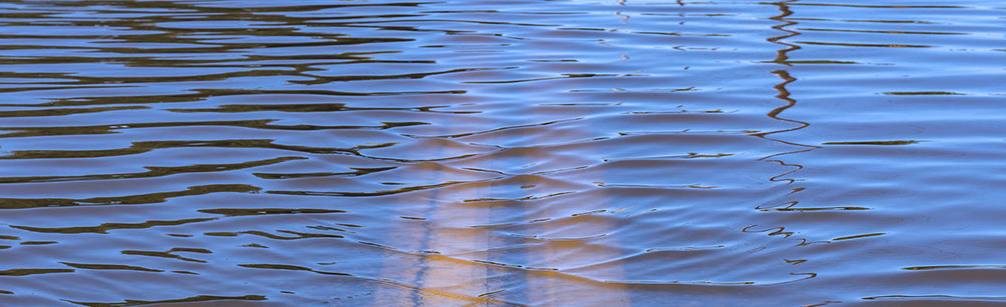 Close up of flooded road showing center double yellow line under the water