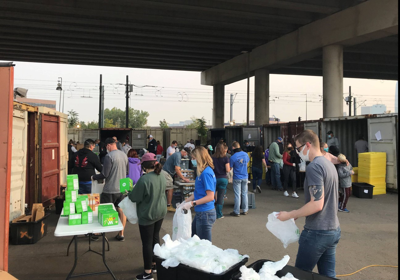 A group of masked volunteers working to create PowerSacks.