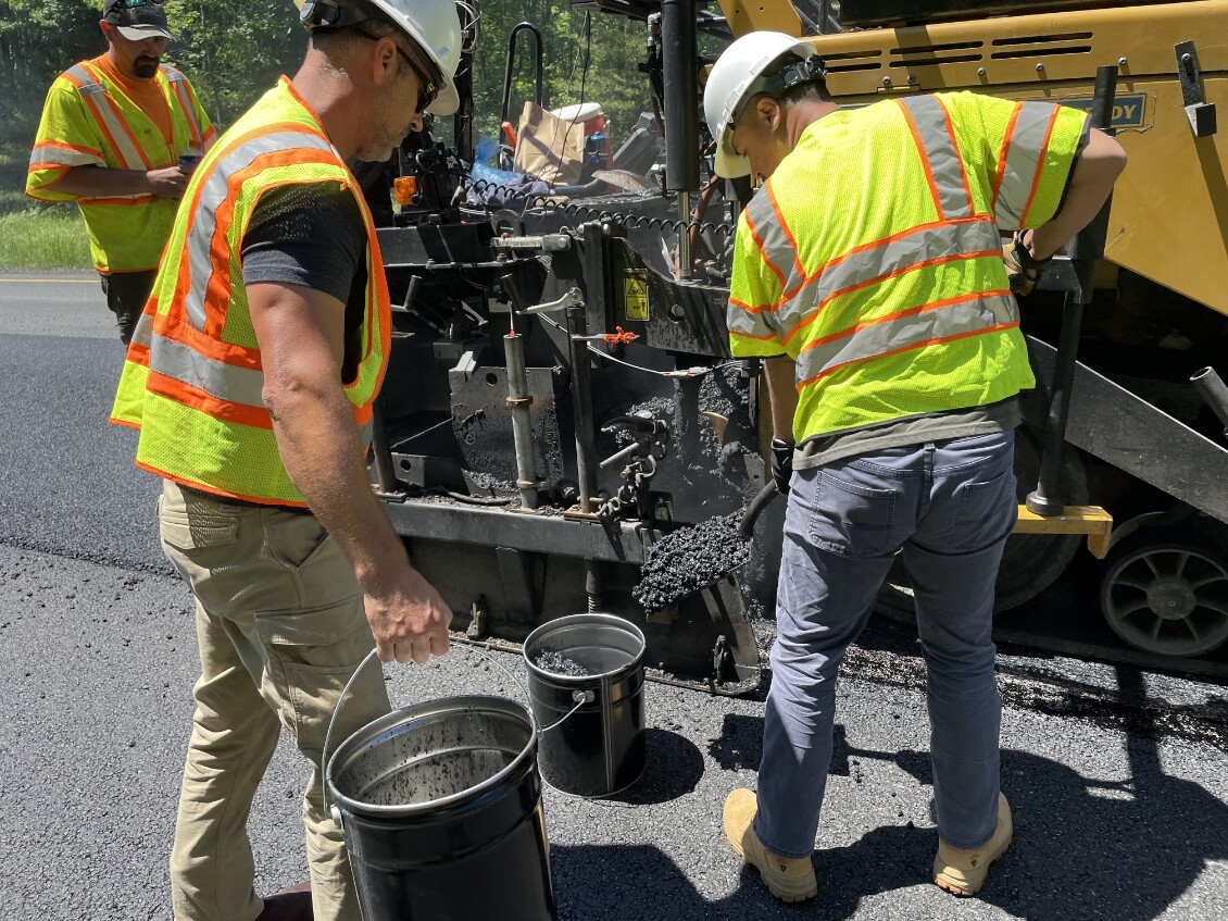 Workers shoveling asphalt