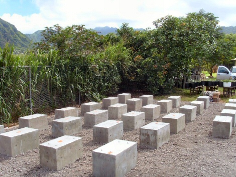 This image shows twenty-eight large concrete blocks placed outside on a layer of gravel.