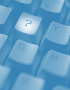 This image shows a close up view of a computer keyboard with a spotlight on the 'question mark' key