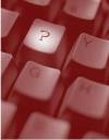 This image shows a close up view of a computer keyboard with a spotlight on the "question mark" key