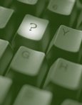 This image shows a close up view of a computer keyboard with a spotlight on the "question mark" key