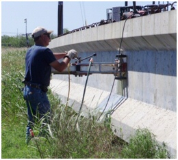 This figure is a photograph of a man extracting cores from a precast concrete girder.