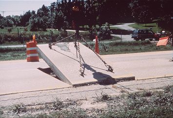 Figure 10 photo of a section of concrete pavement being lifted out with steel chains