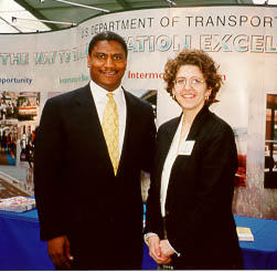 Transportation Secretary Rodney Slater and Gail Edwards, FHWA, pose in front of the ONE DOT Intermodal exhibit.