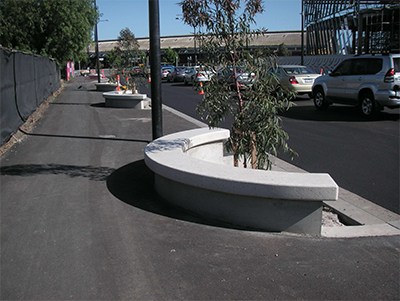 Another view of the curved seating with trees along a busy road.
