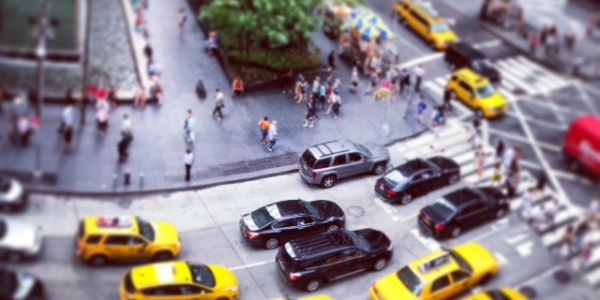 Cars on busy street yield to pedestrians.