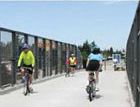 People biking across a bridge.