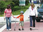 A child with a scooter walks with two adults along the Indianapolis Cultural Trail.