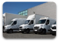 Photo of fleet of freight trucks in front of warehouse