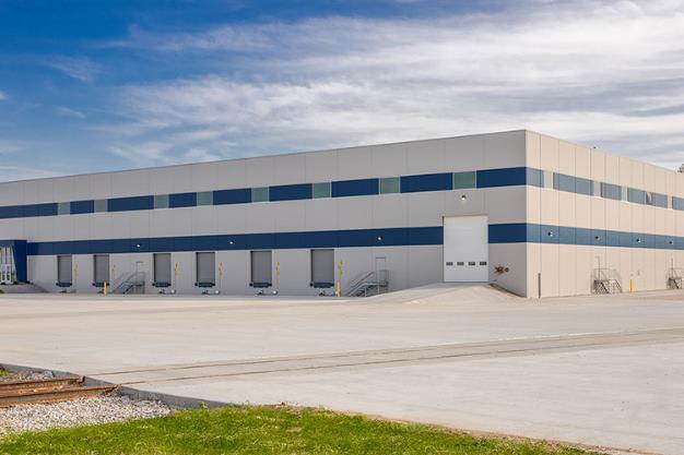 Photo showing exterior of new Washington I-69 Cross-dock Warehouse. Includes view of truck parking and loading docks.
