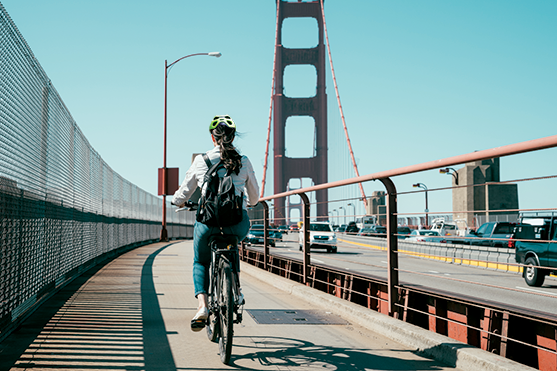 A single bicyclist on a bridge.